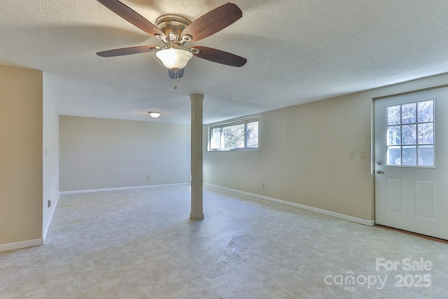 basement with a textured ceiling and ceiling fan