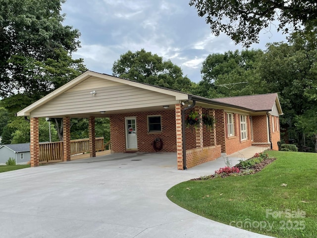 ranch-style home featuring a front lawn and a carport