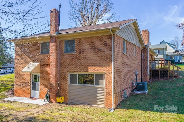 rear view of house featuring a wooden deck, a yard, and central AC unit