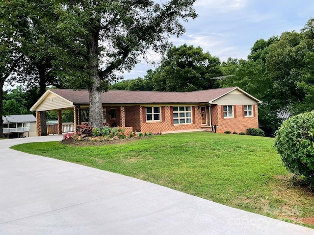 ranch-style house featuring a front lawn and a carport