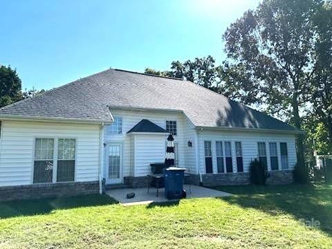 rear view of property featuring a yard and a patio