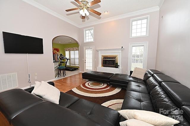 living room featuring a wealth of natural light, wood-type flooring, and ornamental molding