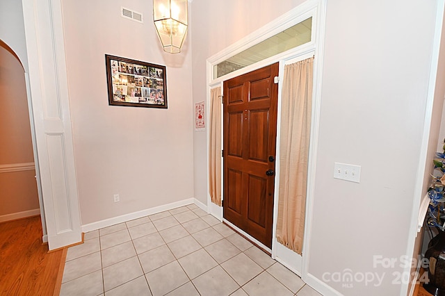 foyer featuring light wood-type flooring and an inviting chandelier