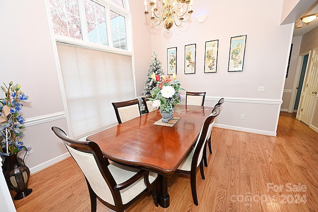 dining room with light hardwood / wood-style floors and a notable chandelier