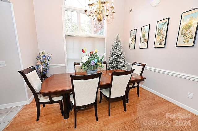 dining space featuring a notable chandelier and light wood-type flooring