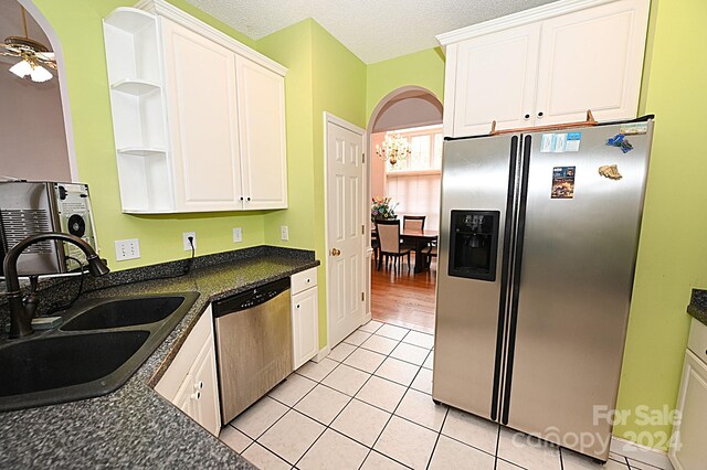 kitchen featuring white cabinetry, sink, ceiling fan, stainless steel appliances, and light tile patterned floors