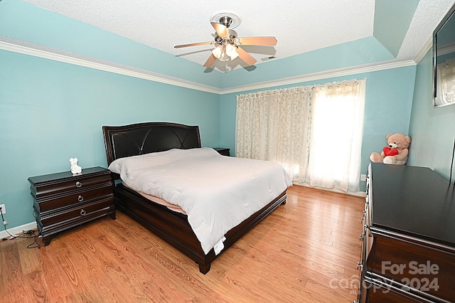 bedroom with a textured ceiling, ceiling fan, light hardwood / wood-style floors, and crown molding