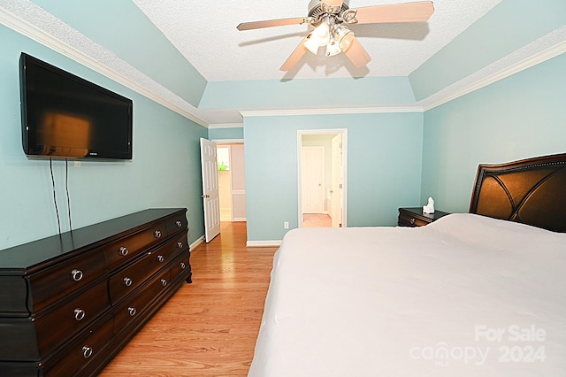 bedroom featuring ceiling fan, ensuite bathroom, light hardwood / wood-style floors, and a textured ceiling