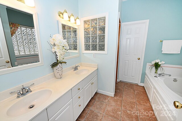 bathroom featuring tile patterned floors, a washtub, and vanity