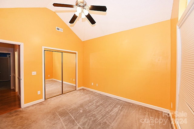 unfurnished bedroom with carpet flooring, a closet, high vaulted ceiling, and ceiling fan