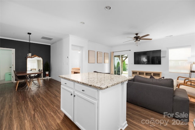 kitchen with hanging light fixtures, a center island, ceiling fan, dark wood-type flooring, and white cabinets