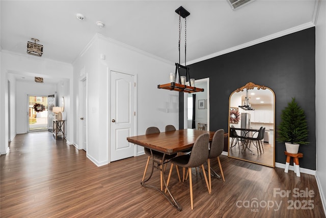 dining space featuring ornamental molding and dark wood-type flooring