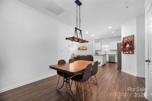 dining space with ornamental molding, dark hardwood / wood-style flooring, and sink