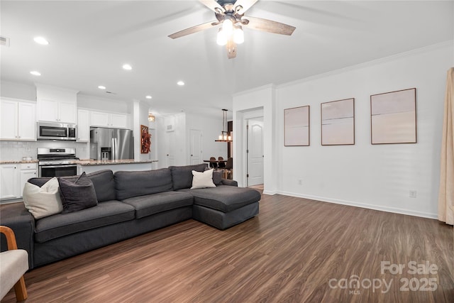 living room featuring dark hardwood / wood-style flooring, ceiling fan, and crown molding