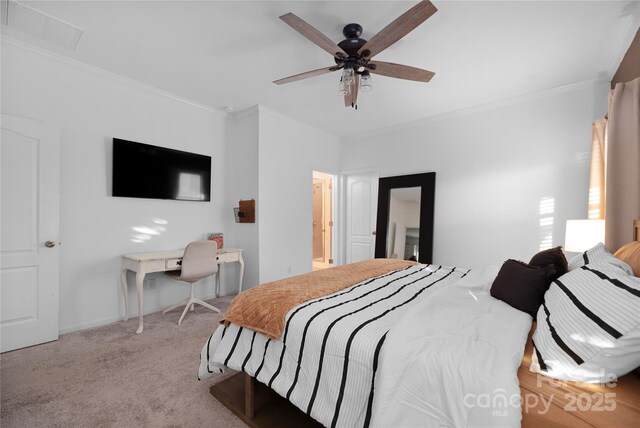 bedroom featuring ceiling fan, light carpet, ornamental molding, and ensuite bath