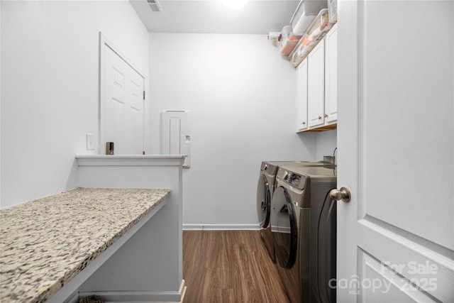 laundry area featuring washing machine and dryer, cabinets, and dark hardwood / wood-style floors