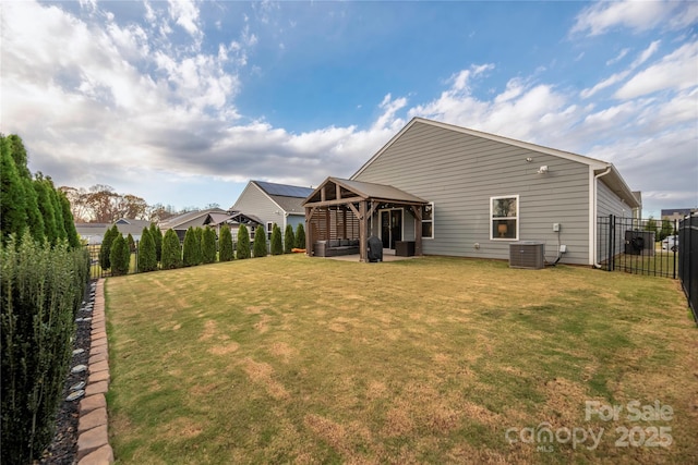 rear view of house featuring a lawn, central AC, a patio area, and a gazebo