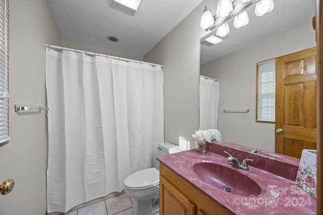 bathroom featuring tile patterned flooring, vanity, toilet, and a textured ceiling