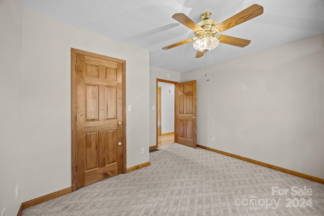 bedroom with ceiling fan, a textured ceiling, and light carpet