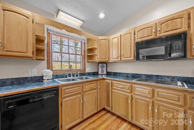 kitchen with lofted ceiling, black appliances, sink, light wood-type flooring, and a textured ceiling