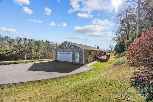 view of side of property with a yard, a garage, and a deck