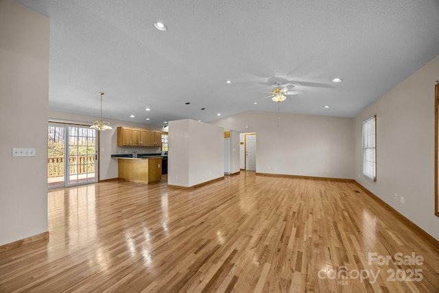 unfurnished living room featuring light wood-style floors, vaulted ceiling, ceiling fan with notable chandelier, and recessed lighting