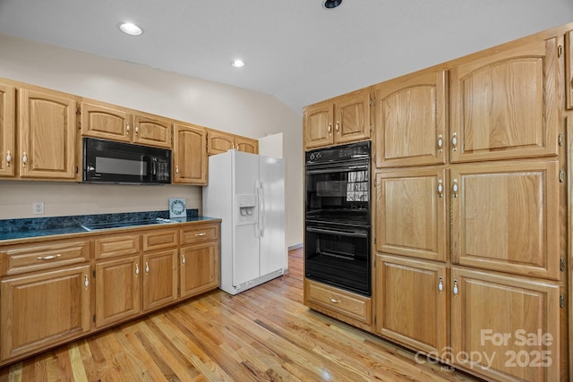 kitchen featuring dark countertops, light wood-style floors, recessed lighting, lofted ceiling, and black appliances