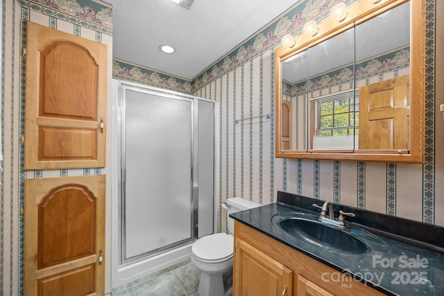 full bathroom with vanity, toilet, wallpapered walls, a textured ceiling, and a stall shower