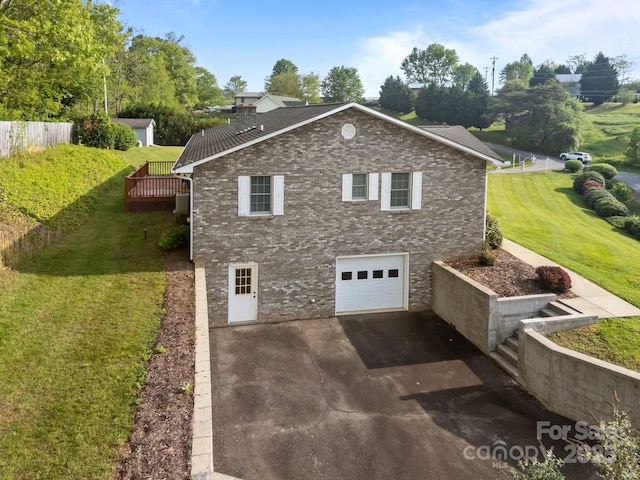 view of side of home featuring a garage, a yard, driveway, and brick siding