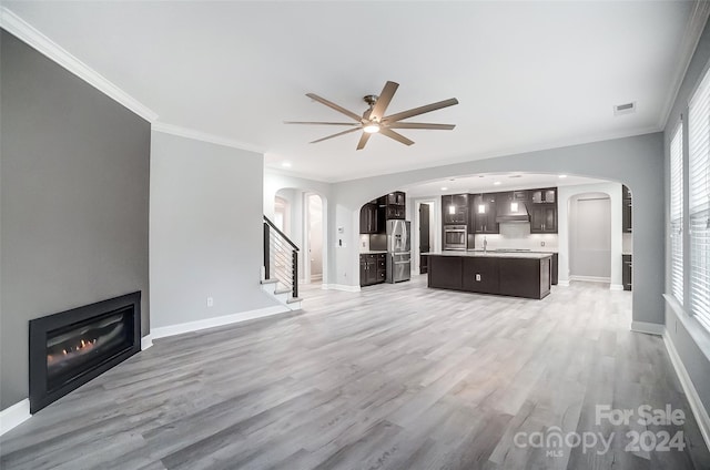 unfurnished living room with ceiling fan, light hardwood / wood-style floors, and ornamental molding