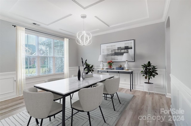 dining room featuring crown molding, light hardwood / wood-style floors, and an inviting chandelier