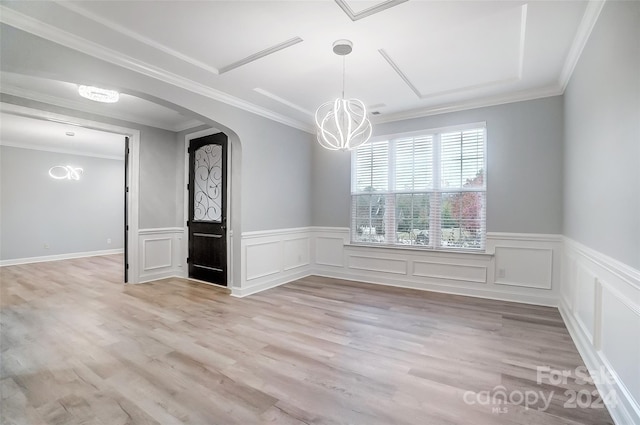 unfurnished room featuring a chandelier, light hardwood / wood-style flooring, and ornamental molding