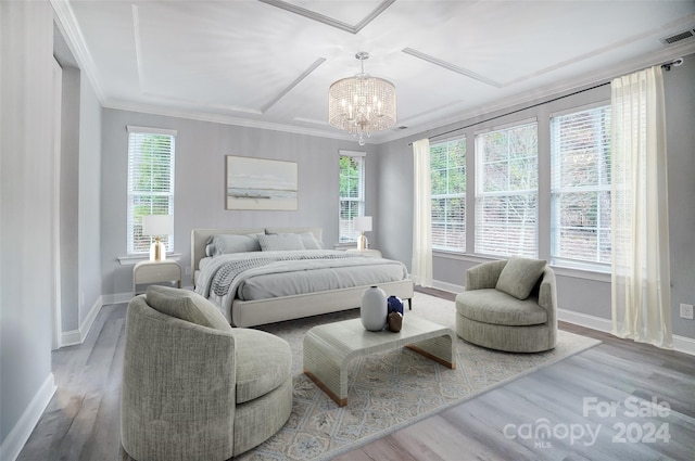 bedroom featuring hardwood / wood-style floors, an inviting chandelier, multiple windows, and ornamental molding