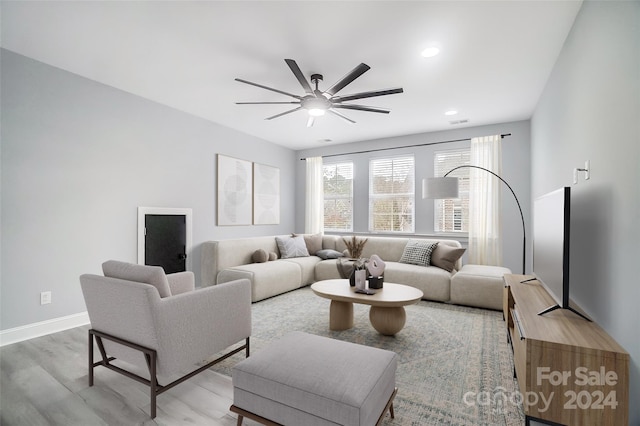 living room with light hardwood / wood-style floors and ceiling fan