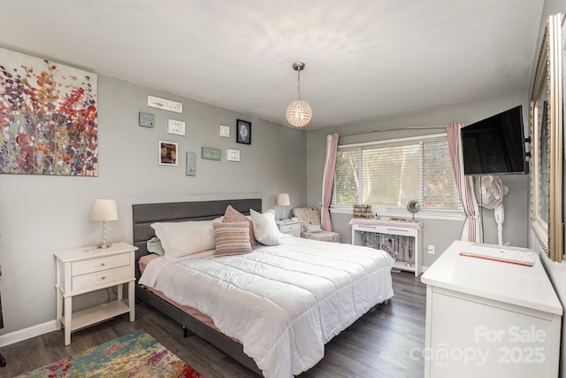 bedroom with dark wood-type flooring and baseboards