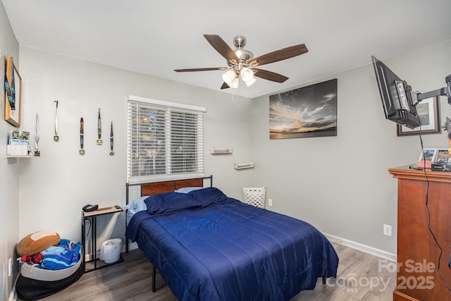 bedroom featuring ceiling fan, baseboards, and wood finished floors