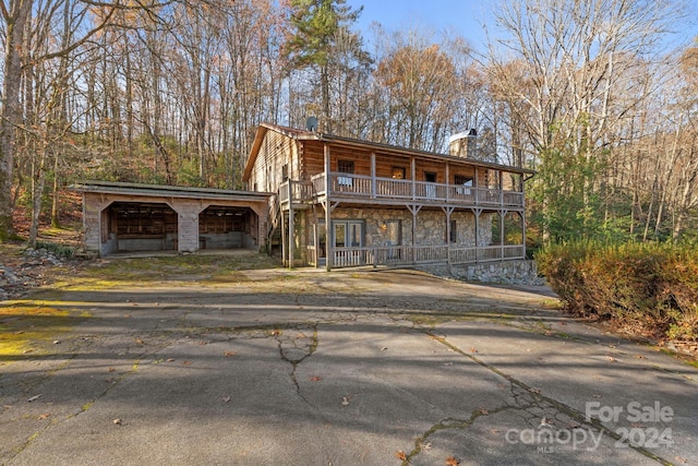 view of front of house featuring an outbuilding and a balcony