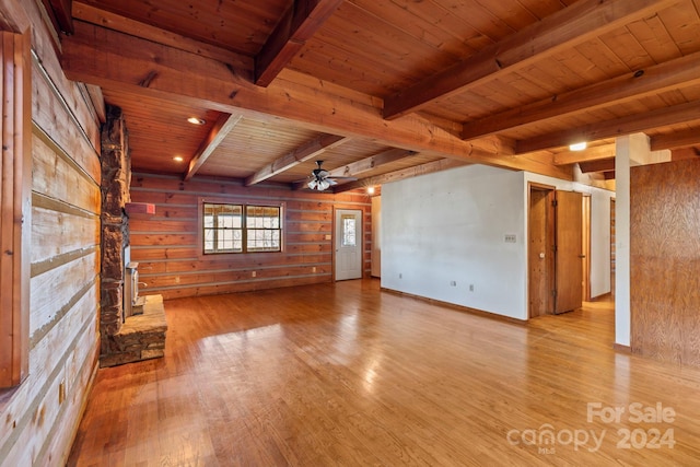 unfurnished living room with beamed ceiling, wood ceiling, and light hardwood / wood-style flooring