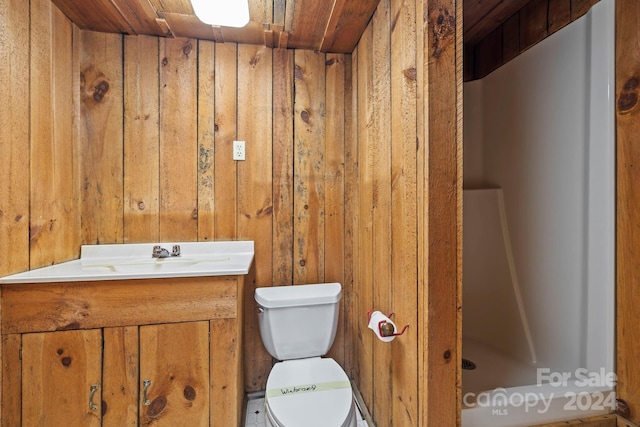 bathroom featuring vanity, toilet, wood ceiling, and wood walls