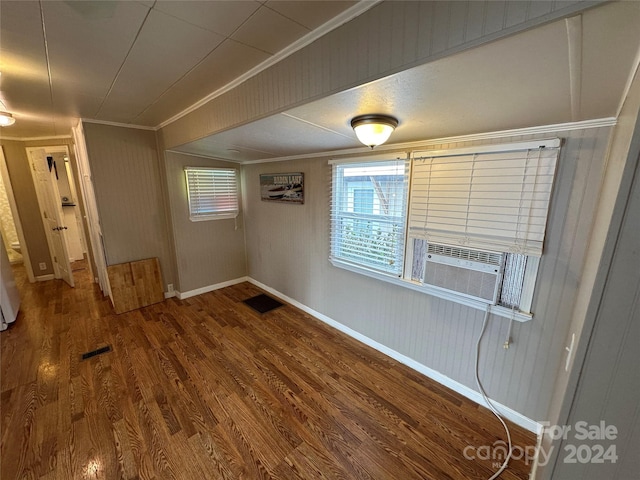 empty room with hardwood / wood-style floors, a healthy amount of sunlight, ornamental molding, and cooling unit