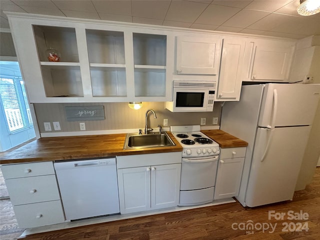 kitchen with white cabinets, butcher block counters, white appliances, and sink