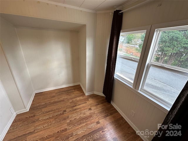 spare room featuring crown molding and dark wood-type flooring