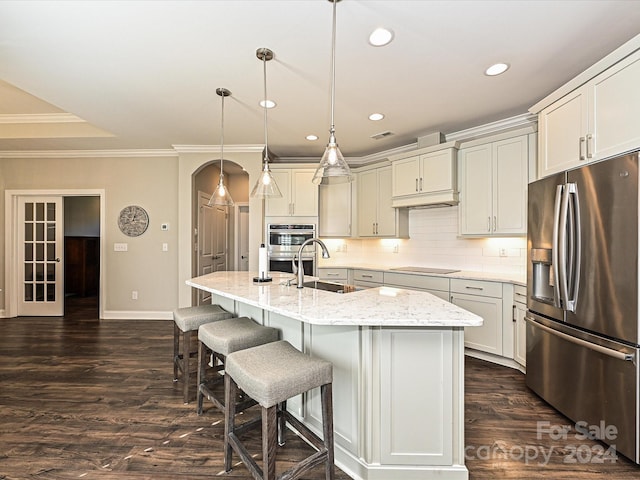 kitchen featuring light stone countertops, sink, dark wood-type flooring, pendant lighting, and appliances with stainless steel finishes