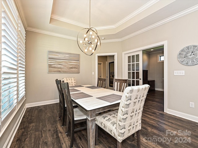 dining space featuring a raised ceiling, crown molding, dark wood-type flooring, and an inviting chandelier