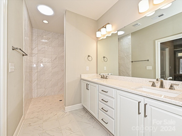 bathroom featuring a tile shower and vanity