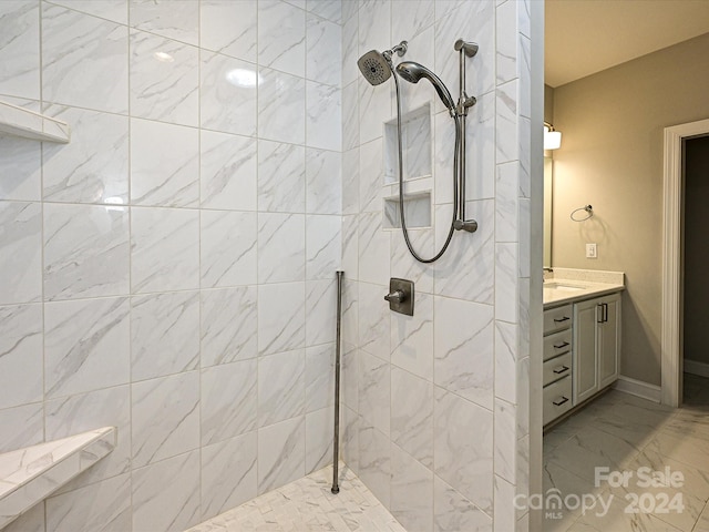 bathroom featuring tiled shower and vanity