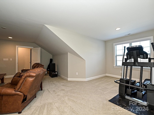 exercise area featuring light colored carpet and vaulted ceiling