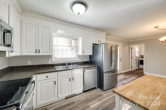 kitchen with stainless steel appliances, sink, ornamental molding, white cabinetry, and light wood-type flooring