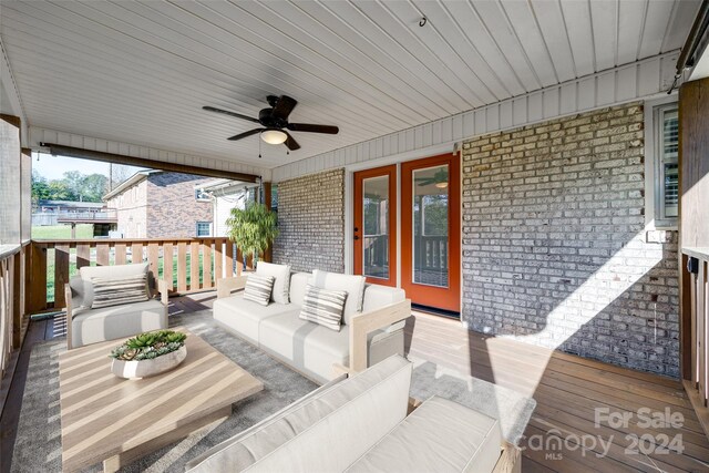 wooden deck with an outdoor hangout area and ceiling fan