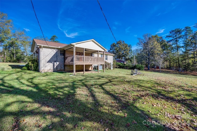 rear view of property with ceiling fan and a yard